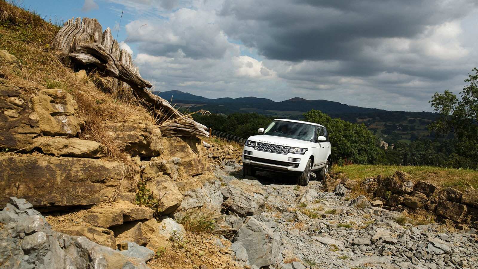 Range Rover (White) driving on rocky terrain