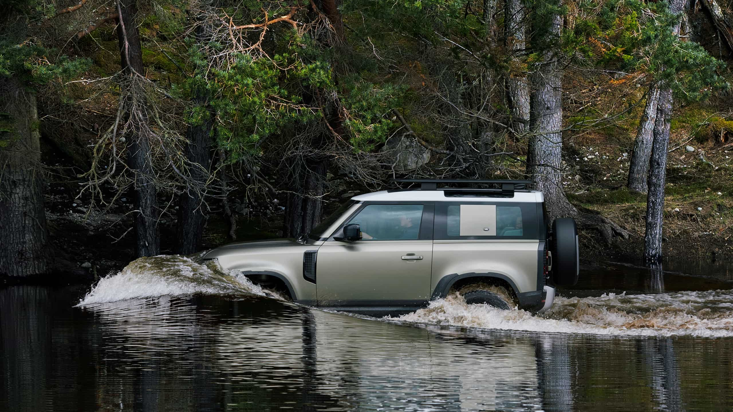 Range Rover Defender driving in a river