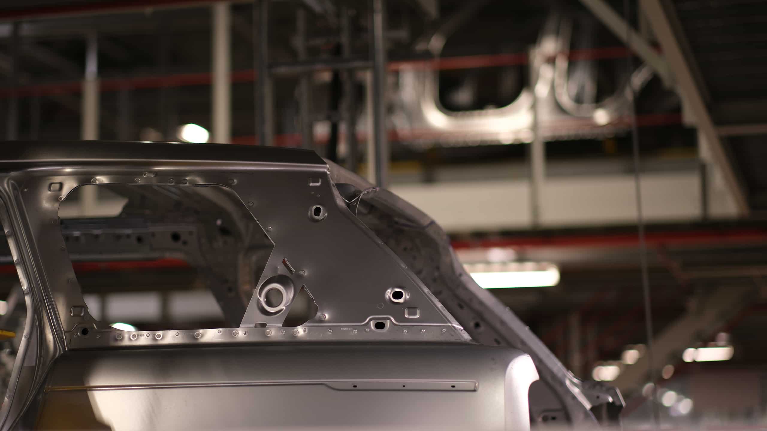 A close-up view of a car chassis on an automotive factory production line.